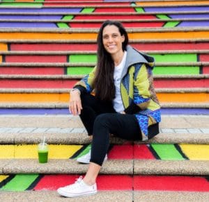 Catherine Morris, founder and MD of Green Home, sitting on some bright steps