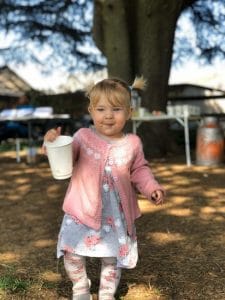 A toddler holding a GREEN HOME cup