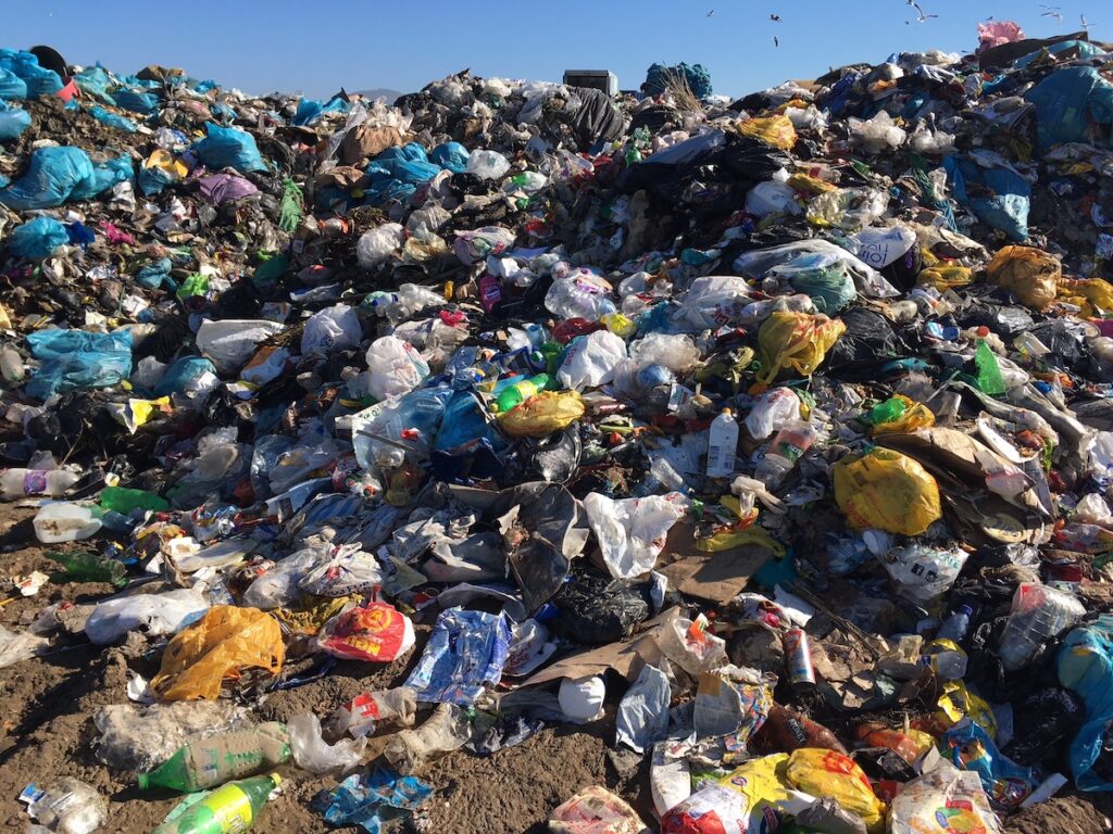 A large landfill heap of mostly plastic waste of different colours 